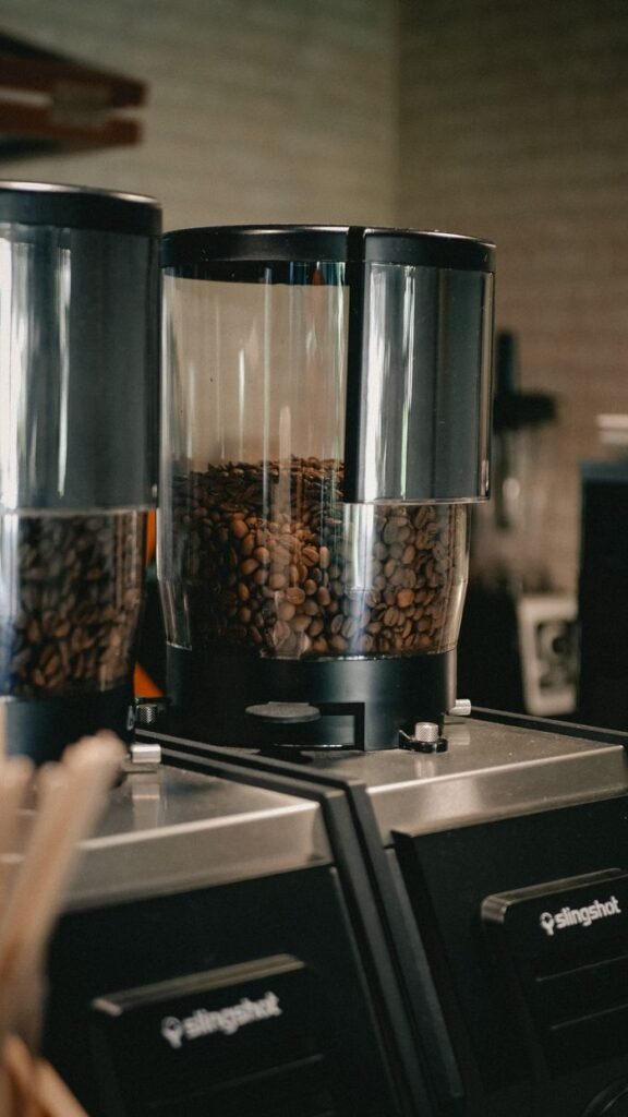 Coffee beans in a grinder at a café, perfect for a fresh brew.